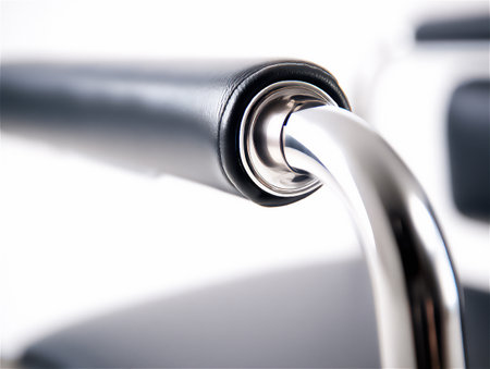 Artistic close-up of black professional office chair armrest with polished chrome fixing mechanism.の素材