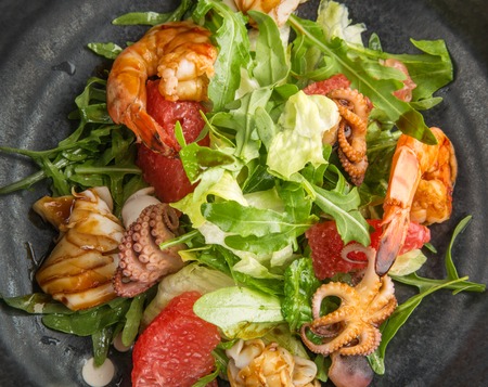 portion of seafood salad on a dark plate in the restaurantの写真素材