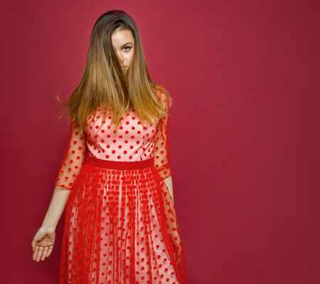 girl with tousled hair looks into the shot with one eyeの写真素材