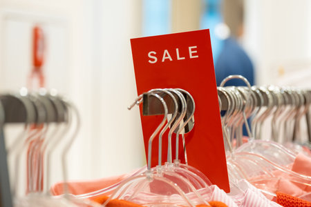 goods in stores and a red sign on sales discounts. mocap for text and concept of sales and trade in light industry.advertising discounts in the clothing storeの写真素材