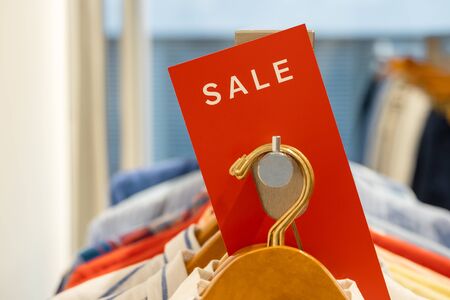 goods in stores and a red sign on sales discounts. mocap for text and concept of sales and trade in light industry. sale in the clothing storeの写真素材