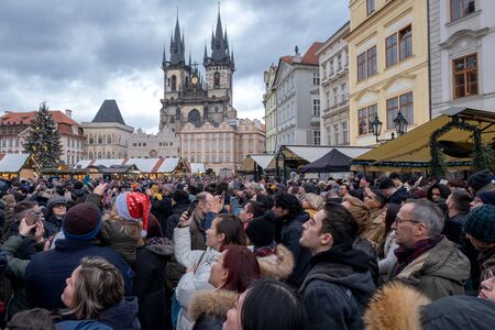 Prague in the Czech Republic on December 23 2019 a crowd of people wait for the ancient clock to strike on the tower. editorialのeditorial素材