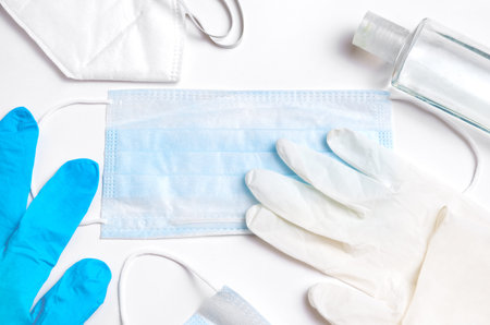 items on a white table for medical protection against viruses. Medical gloves, medical masks and a...