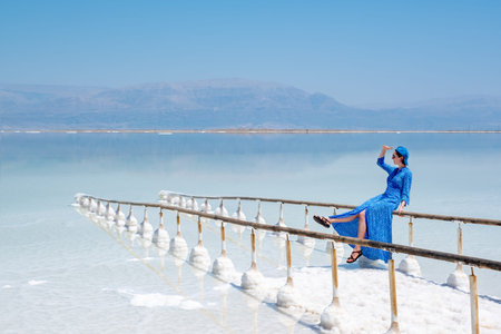 girl in a blue dress on the shores of the dead sea in Israel on a sunny day. beautiful nature of the...