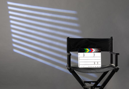 directors chair with clapperboard on gray background of photo studio