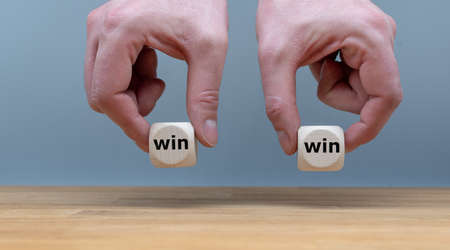 Symbol for a win win situation. Hands are holding two dice with the wordsの写真素材