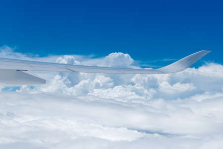 A white wing of an airplane above the clouds.の写真素材