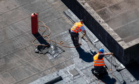 Birds eye view of a roof construction site. Professional bitumen waterproofing on a flat building.のeditorial素材