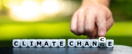Hand turns dice and changes the expression climate change to climate chance.