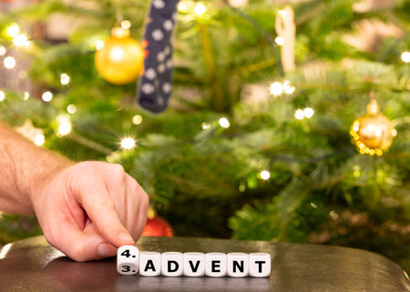 Hand turns dice and changes the German expression 3. Advent (3rd advent) to 4. Advent (4th advent).