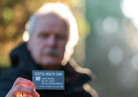 Senior citizen showing a digital health card.の写真素材