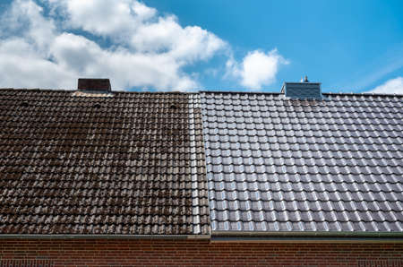 A half cleaned house roof shows the before and after effect of a roof cleaning.の写真素材