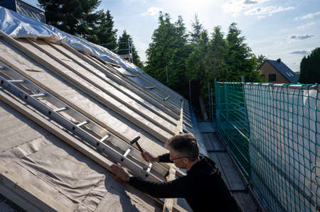 Roofer fixing new insulation on the roof of an old house.の写真素材