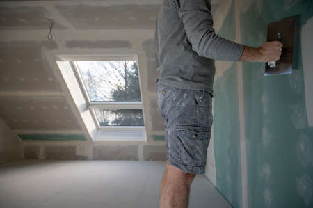 Man plastering drywall in a private house.の写真素材
