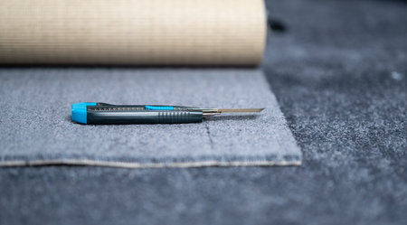 Carpet cutter placed on a new carpet.の写真素材