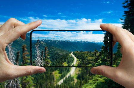 Tourist taking a picture with a mobile phone at the national park in Washington, USA.の写真素材