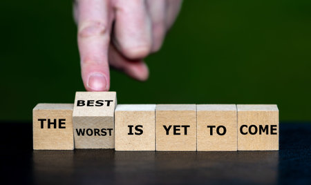 Hand turns dice and changes the expression 'the worst is yet to come' to 'the best is yet to come'.