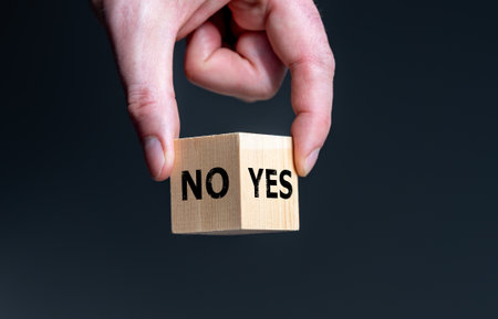 Symbol for the decision between yes and no. Wooden cube with the words 'yes' and 'no'.の写真素材