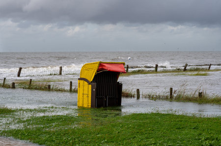 Beach chairs at the beach of Altenbruch near Cuxhaven in Germany. Beach flooded after a summer storm...