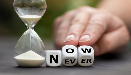 Symbol for getting started. Hand turns dice and changes the word never to now.の素材