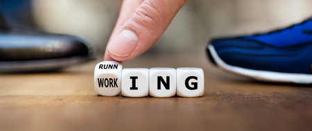 Hand turns dice and changes the word working to running.の素材
