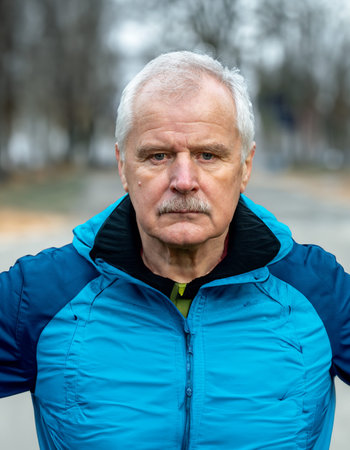 Senior man in sports wear looking into the camera. Symbol for elderly people being active and doing...