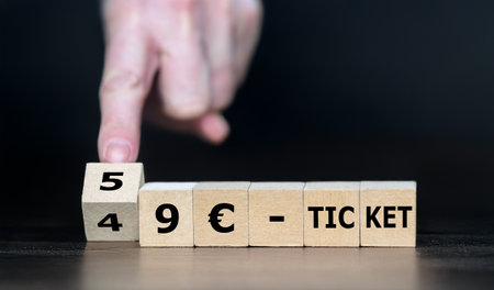 Hand turns cube and changes the expression '49 EUR ticket' to '59 EUR ticket'. Symbol for the price increase of the German railway ticket.の写真素材