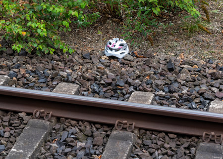 A child helmet next to train tracks.の写真素材