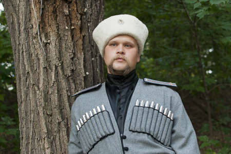 Young man in a cossack clothes in a forestの写真素材