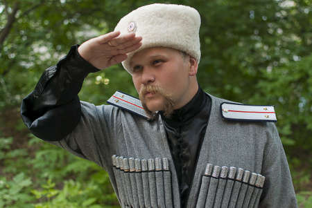 Young man in a cossack clothes in a forestの写真素材