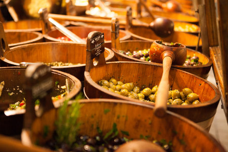 Bowls of various olives for sale at a market place