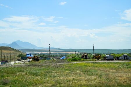 Old agricultural machinery stands in a village on a site with agricultural machineryの写真素材