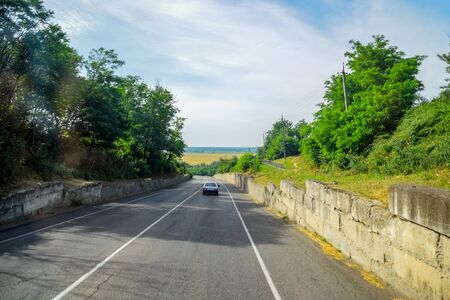 Asphalt road on which cars go. Landscape view from the cabの写真素材