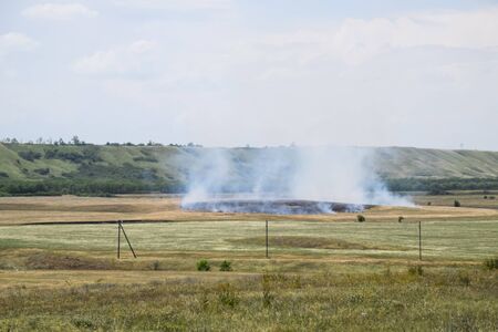 Fire in the field where hay was grown. burning dry grassの写真素材