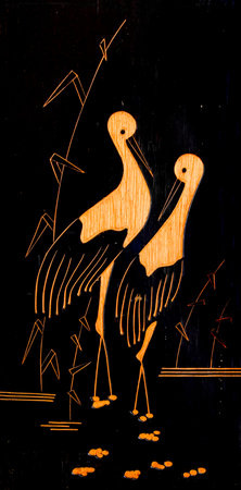 Two cranes stand in a swamp. Painting on a wooden plank.