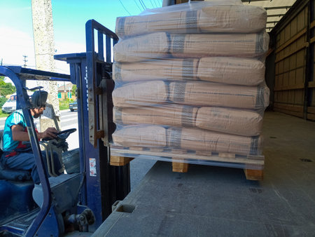 Krasnodar, Russia - June 13, 2019: Unloading bags of cement from a truck with a forklift.のeditorial素材