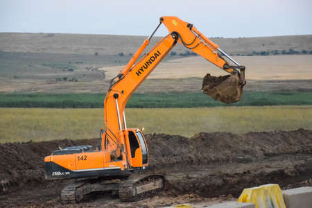 Taman, Russia - July 9, 2019: Excavator on the construction of the road. Heavy machinery for construction.のeditorial素材
