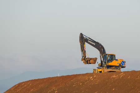 Taman, Russia - July 9, 2019: Excavator on the construction of the road. Heavy machinery for construction.のeditorial素材
