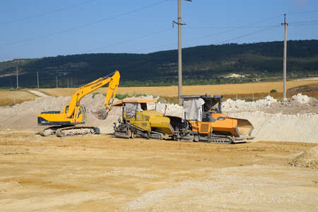 Taman, Russia - July 9, 2019: Excavator on the construction of the road. Heavy machinery for construction.のeditorial素材