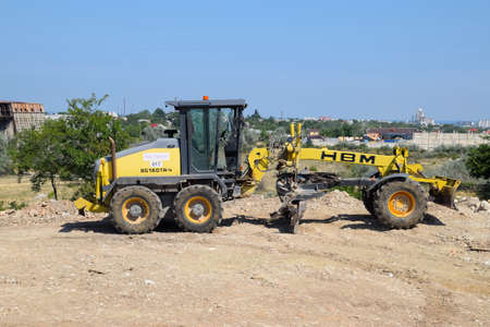 Taman, Russia - July 9, 2019: Excavator on the construction of the road. Heavy machinery for construction.のeditorial素材