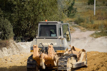 Taman, Russia - July 9, 2019: Excavator on the construction of the road. Heavy machinery for construction.のeditorial素材