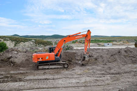 Taman, Russia - July 9, 2019: Excavator on the construction of the road. Heavy machinery for construction.のeditorial素材