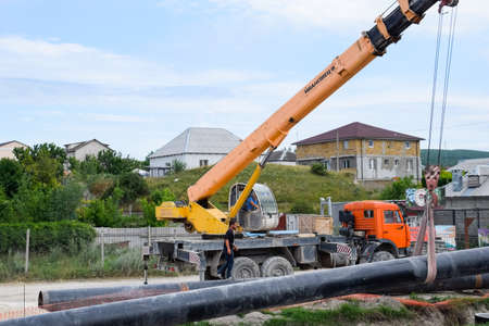 Taman, Russia - July 9, 2019: Excavator on the construction of the road. Heavy machinery for construction.のeditorial素材