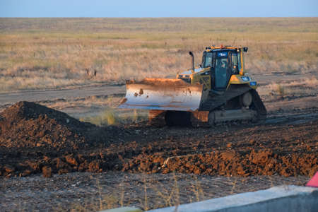 Taman, Russia - July 9, 2019: Excavator on the construction of the road. Heavy machinery for construction.のeditorial素材