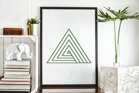 Interior of home space with mock up poster frame, plant, books, tropical leafs and white elephant....