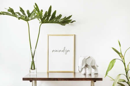 The stylish interior with mock up poster frame, leafs and elephant sculpture. The minimalizm concept of space.の写真素材