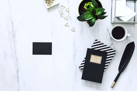 The horizontal view of marble desk with cup of coffee, plant and notes. Concept for mock up bussines...