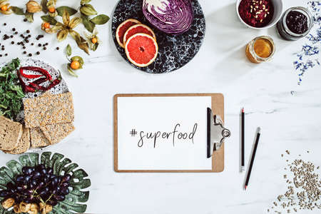 Super food on the white marble table. Flat lay. Variuos vegetables ingredients and healthy food for vegetarians. Mock up concept, top view.の写真素材