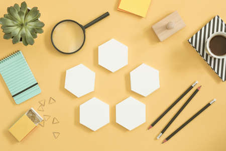 Creative desk with mock up hexagon shapes and phone for project. Concept of modern approach to...