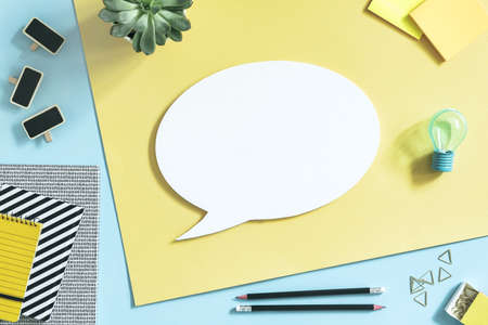 The top view of creative desk with mock up cloud, office accessories and succulent. Blue and yellow...